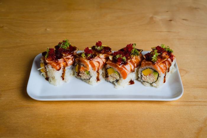 Yama roll topped with salmon, red tobiko and lemon