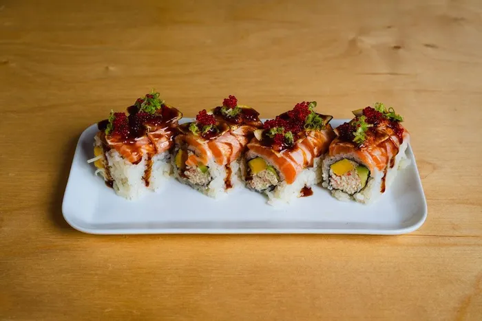 Yama roll topped with salmon, red tobiko and lemon