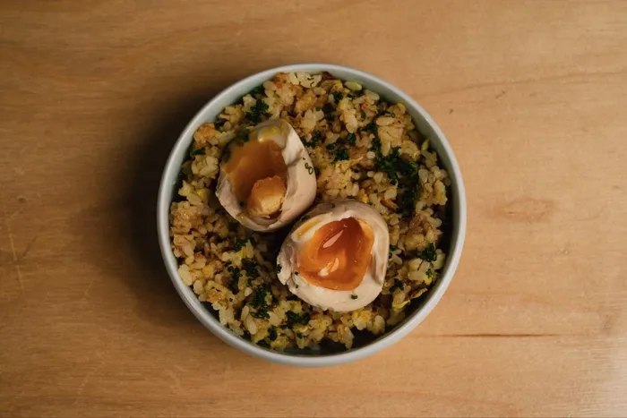 Waretamago bowl with broken marinated egg over fried rice